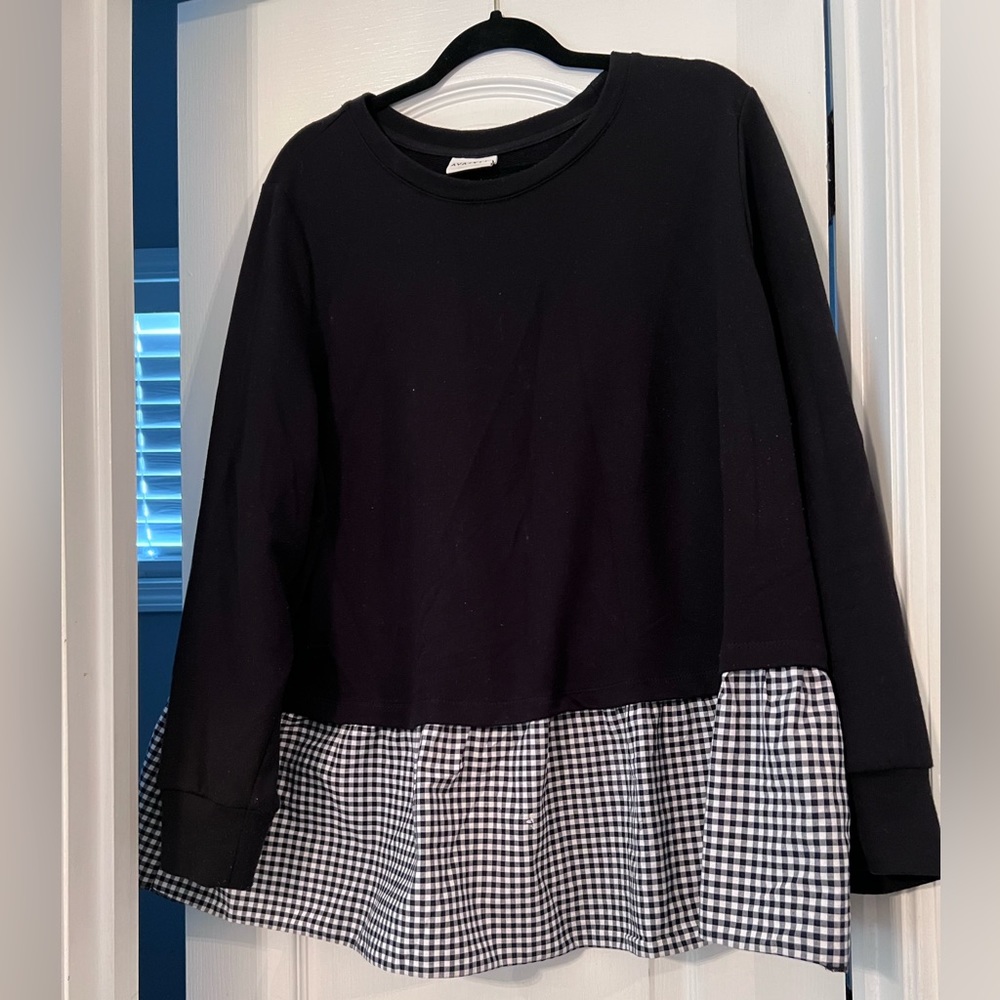 Black and white top. Sweater on top and light plaid material on bottom